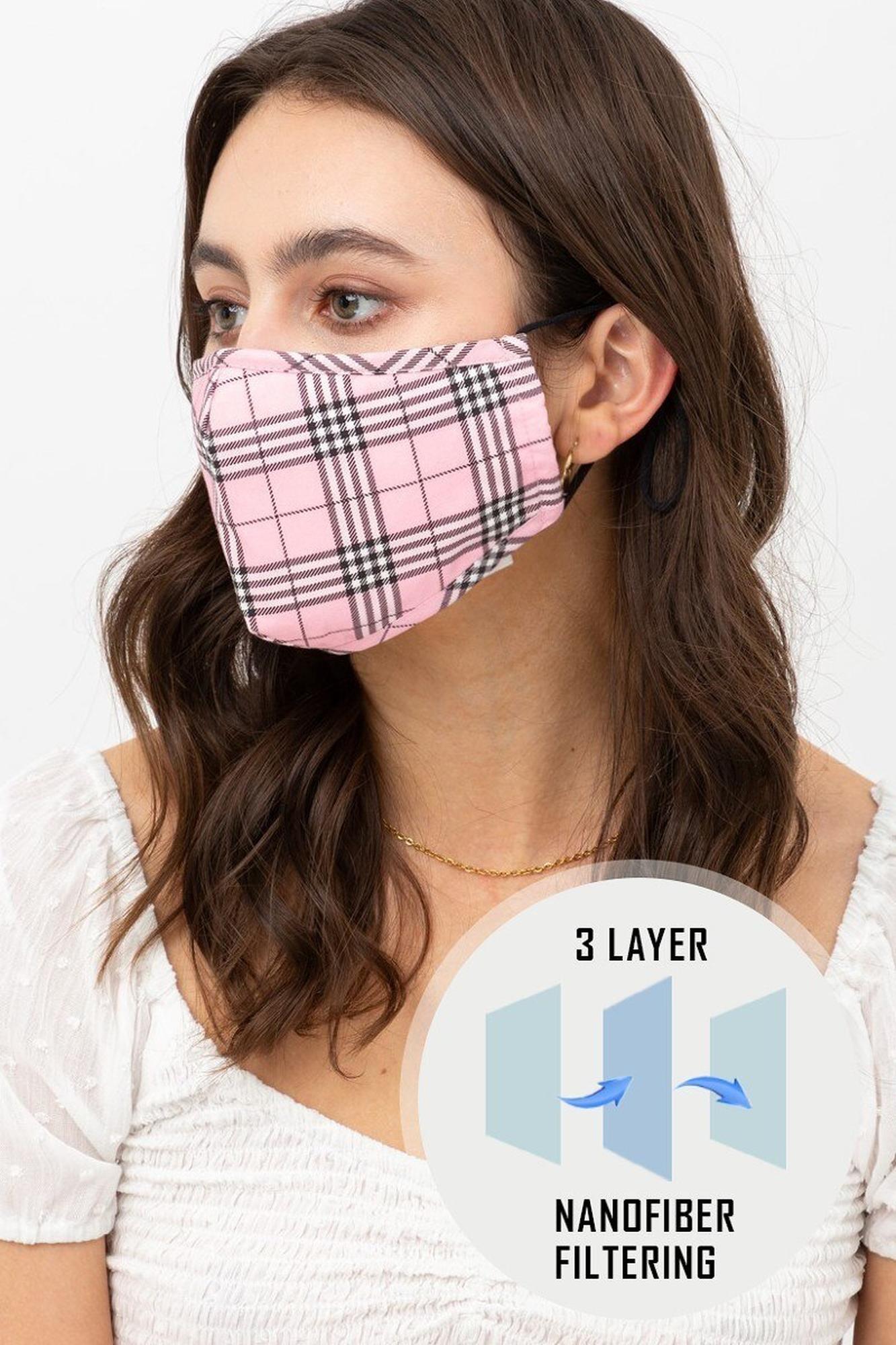 Woman wearing a pink and black plaid face mask with a close-up of the mask's filter technology on a white background.