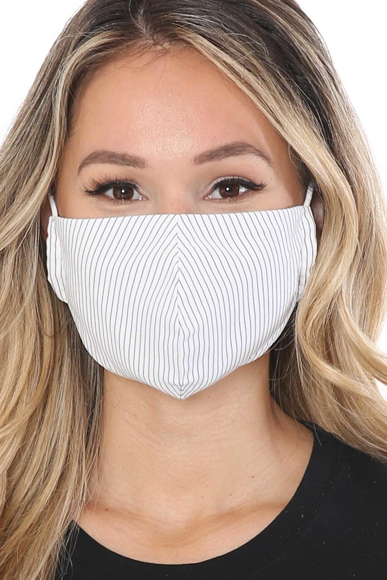 Woman wearing a white striped face mask against a plain background